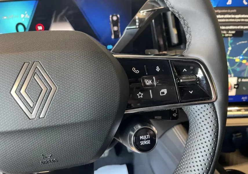 Gros plan sur le volant noir perforé de la Renault Rafale 2025 avec commandes intégrées et bouton Multi Sense visible.