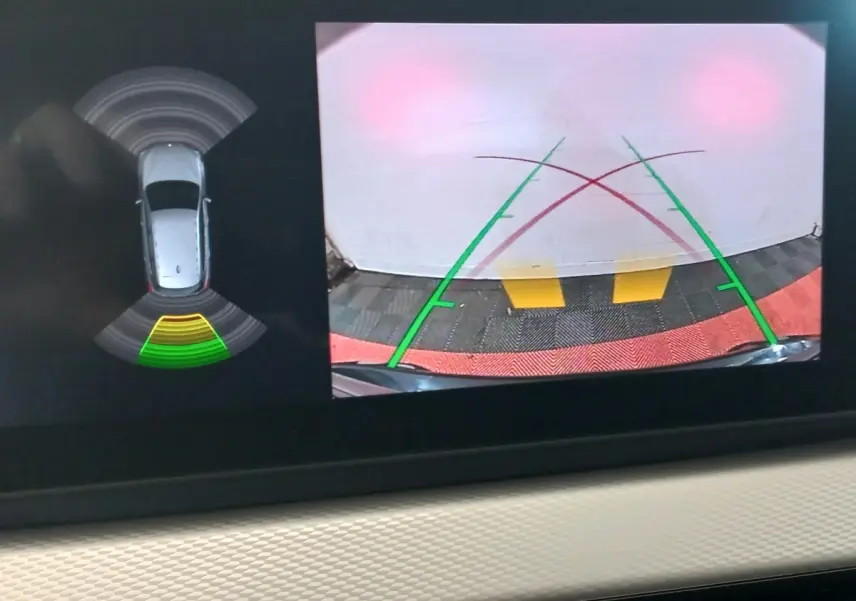 Affichage écran tactile de la caméra de recul et capteurs de stationnement du BMW X1 noir, vue intérieure du tableau de bord.