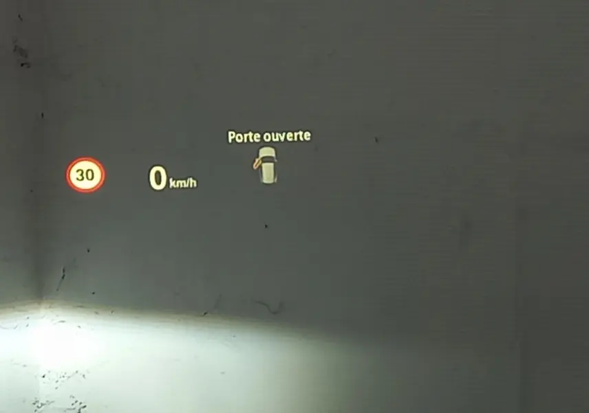 Affichage tête haute BMW X1 noir 2022 montrant vitesse à 0 km/h et alerte porte ouverte côté gauche.