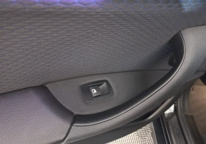 Bouton de commande de lève-vitre sur la porte intérieure côté droit d’un BMW X1 noir 2022 xDrive20d M Sport.