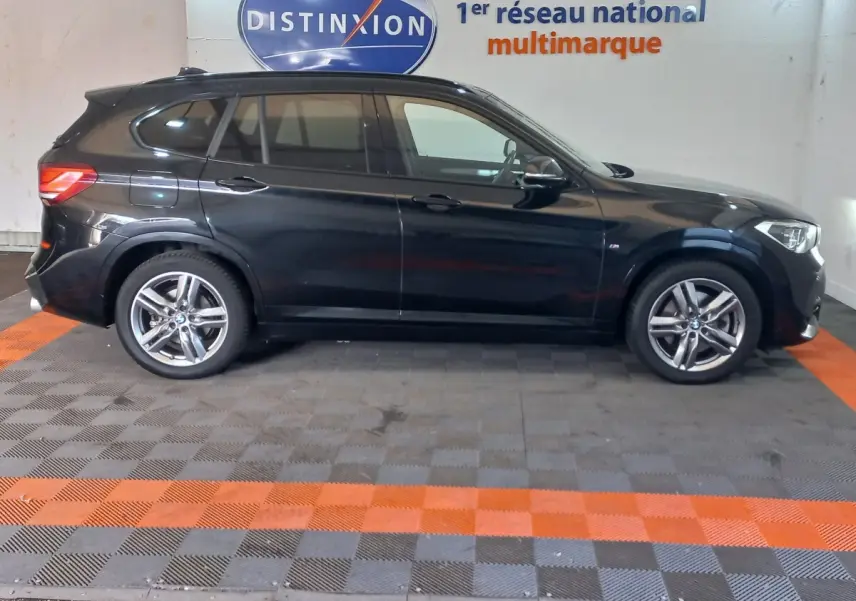 BMW X1 xDrive20d M Sport noir vue de profil côté gauche, avec jantes alliage et vitres teintées.