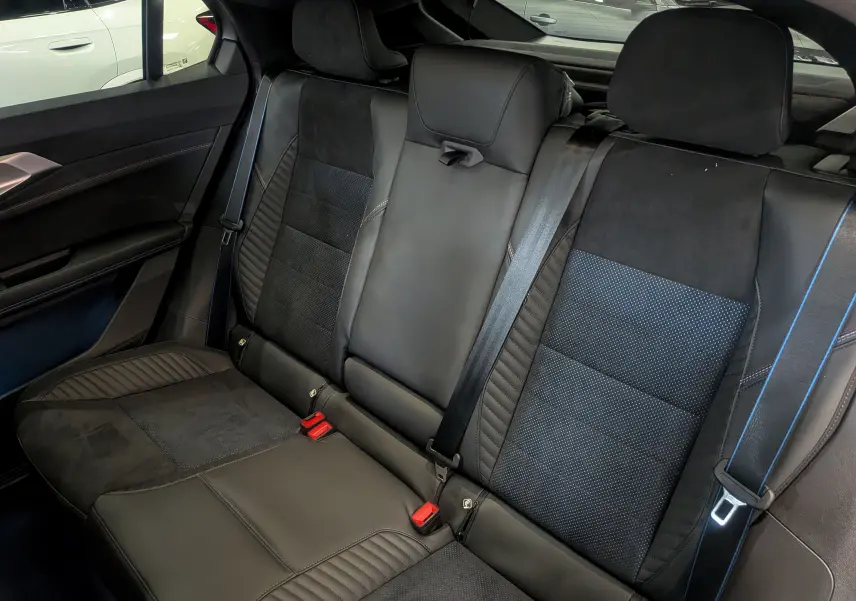 Vue intérieure des sièges arrière en cuir noir et alcantara avec surpiqûres bleues du Renault Rafale hybride rechargeable 2025.