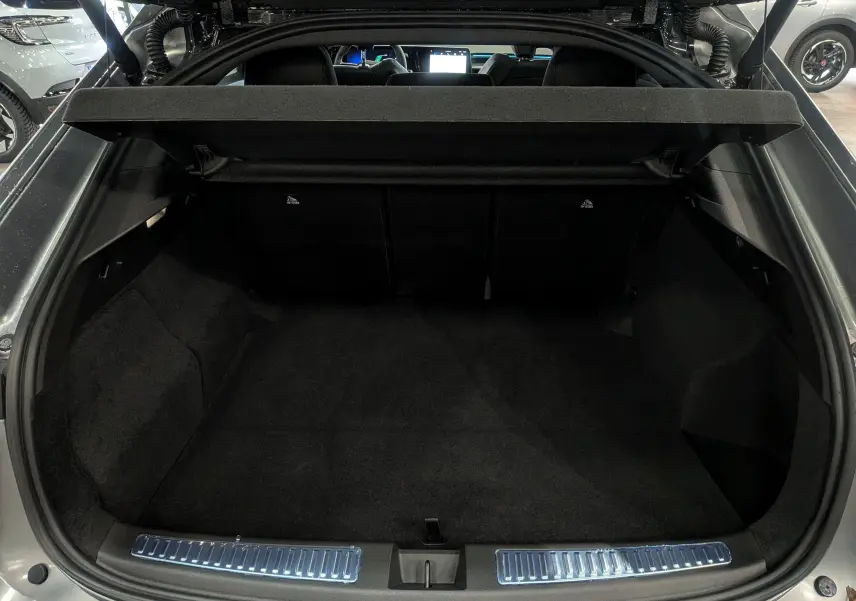 Coffre ouvert vu de l'arrière d'une Renault Rafale gris schiste satin, montrant l'espace de chargement et la tablette arrière.