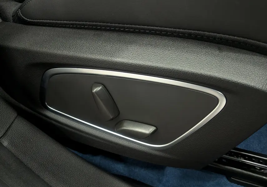 Gros plan sur les commandes électriques de réglage du siège en cuir noir dans l’habitacle du Renault Rafale gris Schiste Satin.