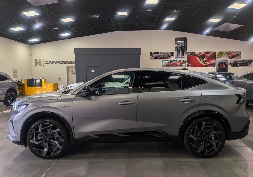 Vue de profil côté gauche du Renault Rafale gris schiste satin, soulignant ses jantes noires et son design sportif 4x4 hybride.