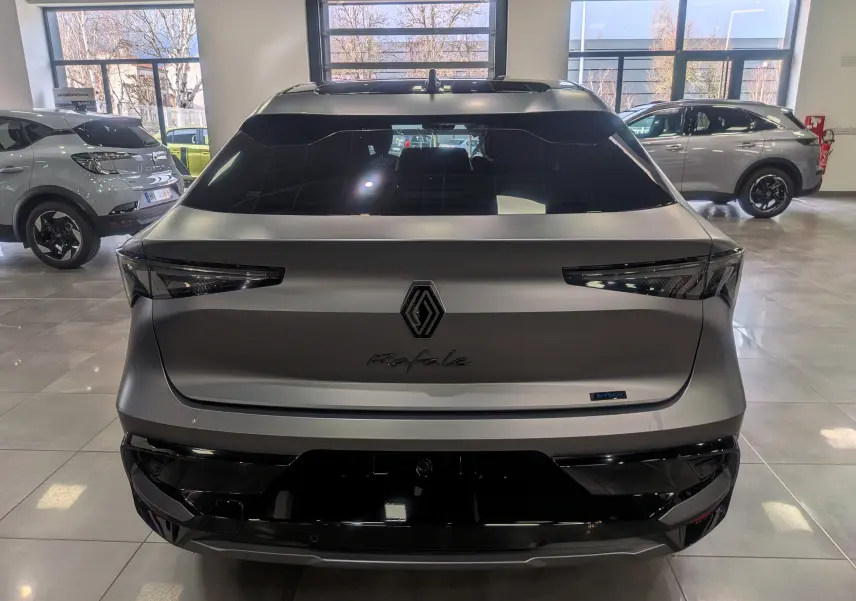 Vue arrière d'une Renault Rafale gris schiste satin avec logo central et feux arrière fins en intérieur showroom.