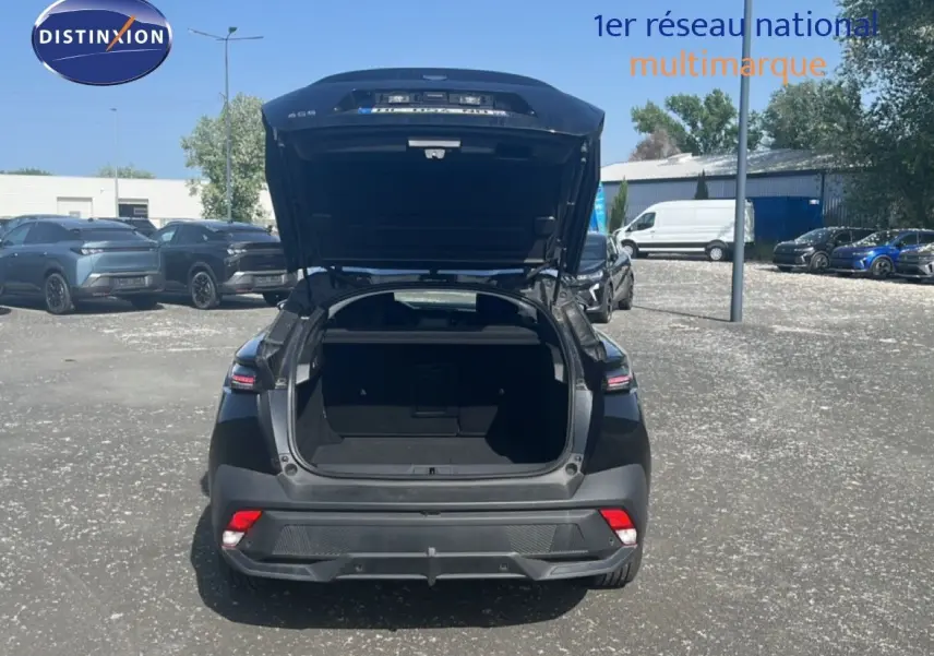 Vue arrière d'une Peugeot 408 noire métal 2025 avec coffre ouvert, soulignant son espace de chargement.