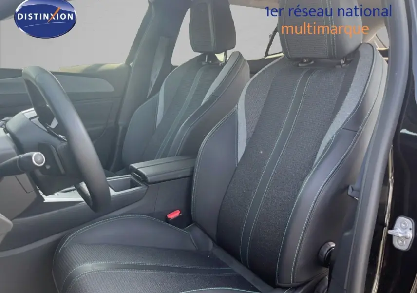 Vue intérieure côté conducteur de la Peugeot 408 noire, sièges en cuir et tissu avec surpiqûres contrastées.