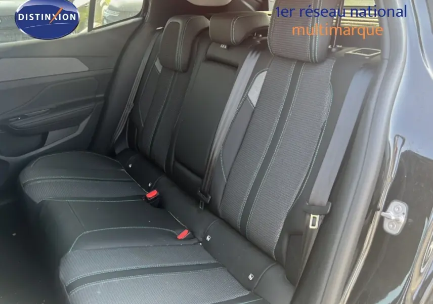Vue intérieure sur la banquette arrière d’une Peugeot 408 noire métal, sièges en tissu et cuir avec surpiqûres contrastées.