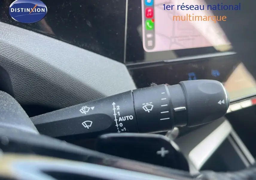 Gros plan sur la commande d’essuie-glace avec affichage tactile en arrière-plan dans un Peugeot 408 noir métal 2025.