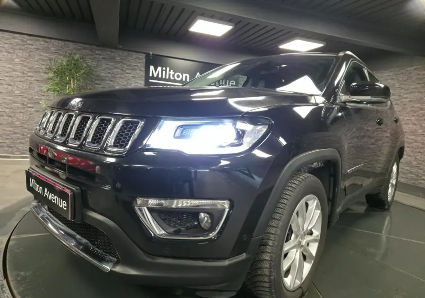 Jeep Compass noir en 3/4 avant droit avec phares LED allumés et jantes alliage 18 pouces visibles.