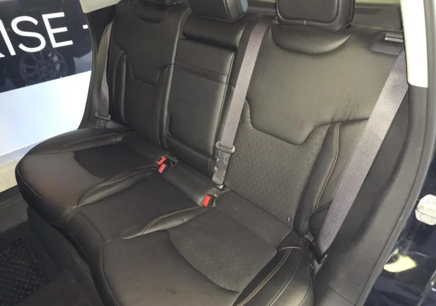 Vue intérieure sur la banquette arrière en simili cuir noir du Jeep Compass 2021, avec ceintures et appuie-têtes visibles.