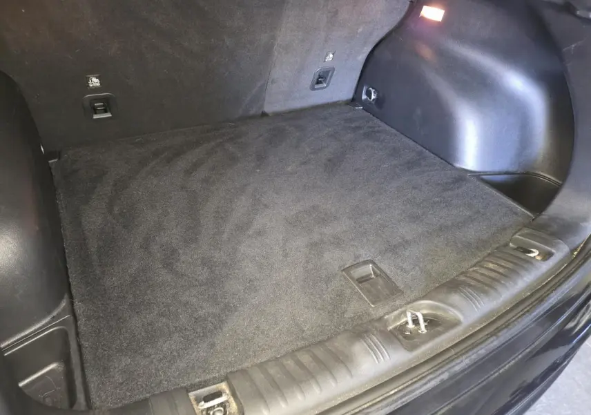 Coffre vide vu de l'arrière d'un Jeep Compass noir 2021 avec tapis de sol en caoutchouc et éclairage intérieur.