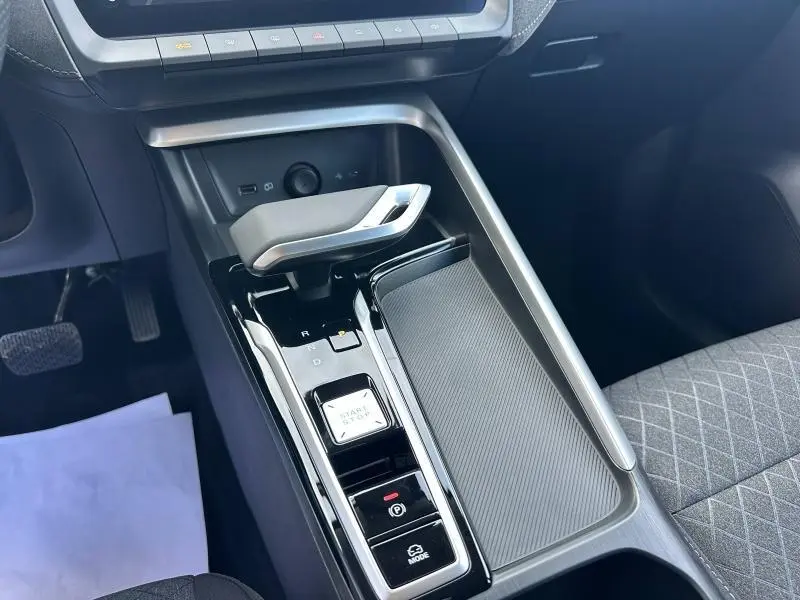 Vue rapprochée de la console centrale noire et grise du MG ZS Hybrid+ 2025 avec levier de vitesse et bouton start/stop.