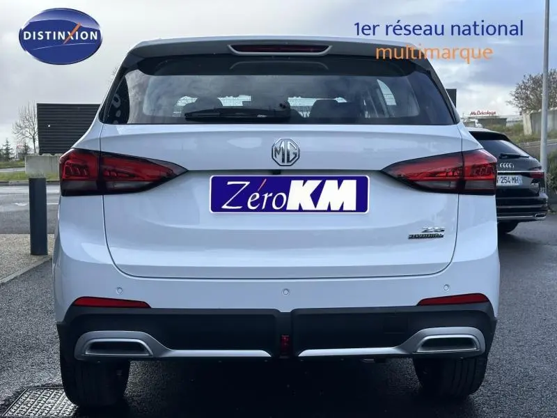 Vue arrière du SUV blanc MG ZS Hybrid+ 197ch Comfort avec feux arrière LED et double sortie d'échappement intégrée.