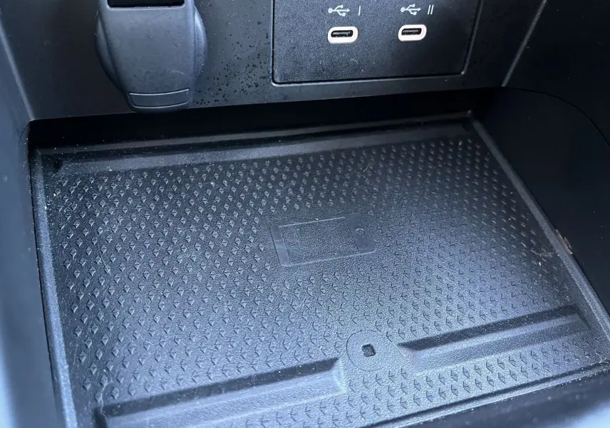 Gros plan sur la zone de recharge sans fil et ports USB du Renault Captur 2025, finition gris rafale toit noir.