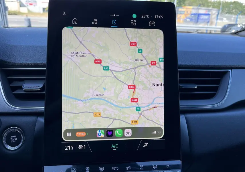 Vue rapprochée de l’écran tactile central du Renault Captur 2025 affichant la navigation GPS et les commandes climatiques.