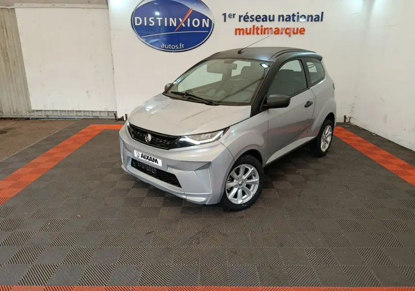 Aixam Ambition 0.5 City Crossline Pack gris foncé vue 3/4 avant droit en intérieur showroom.