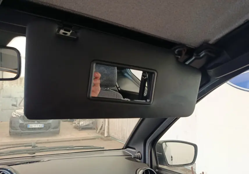 Détail intérieur du pare-soleil avec miroir ouvert côté conducteur d'une Aixam Ambition gris foncé, vue depuis l'habitacle.