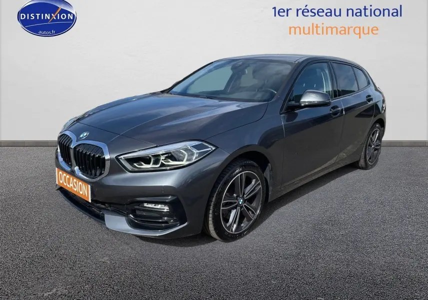 BMW Série 1 gris minéral métal vue 3/4 avant droit avec jantes alliage et calandre double haricot chromée.