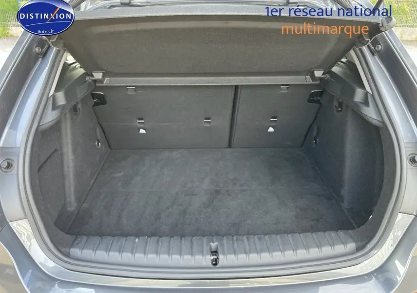 Coffre ouvert d'une BMW Série 1 118i gris minéral métal, vue arrière montrant l'espace de chargement vide.