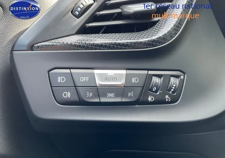 Gros plan sur les commandes d'éclairage à gauche du tableau de bord d'une BMW Série 1 gris minéral métal.