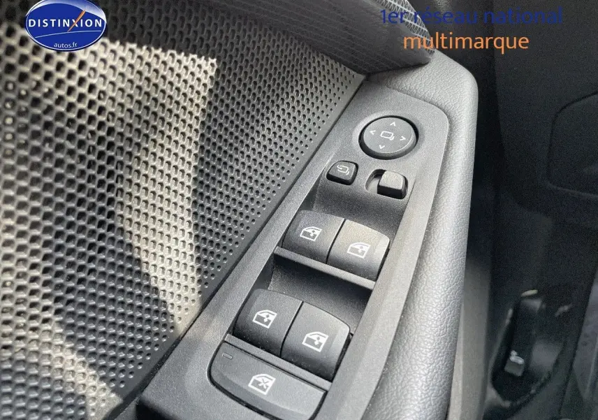 Gros plan sur les commandes des vitres électriques côté conducteur d'une BMW Série 1 gris minéral métal de 2021.
