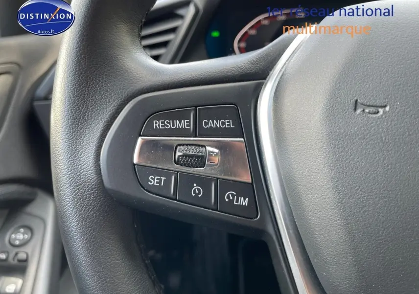 Gros plan sur les commandes au volant en cuir noir de la BMW Série 1 gris minéral, version Edition Sport 2021.