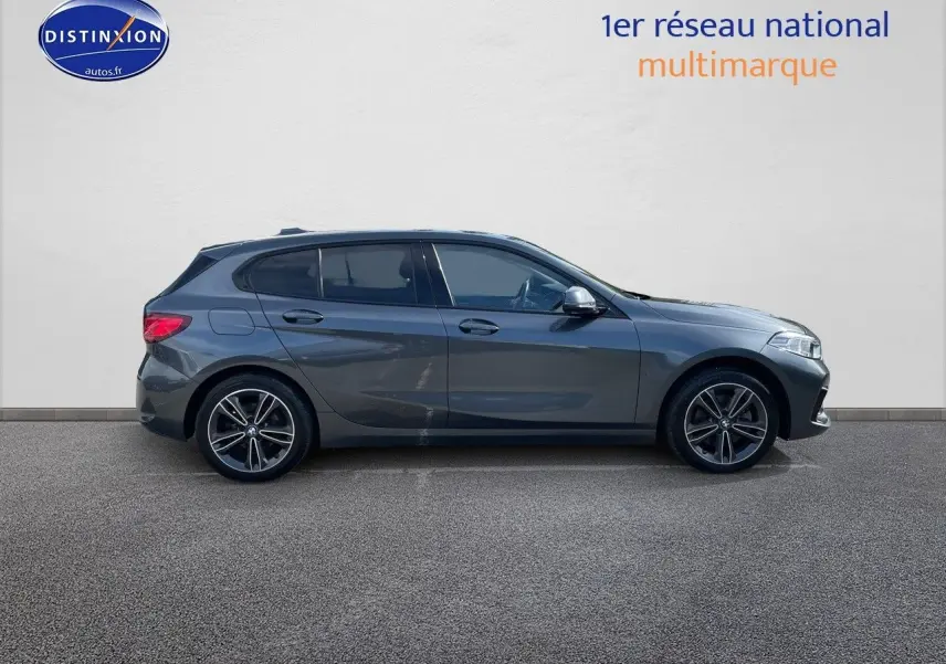Profil droit d'une BMW Série 1 118i gris minéral métallisé avec jantes alliage bicolores, vue extérieure.