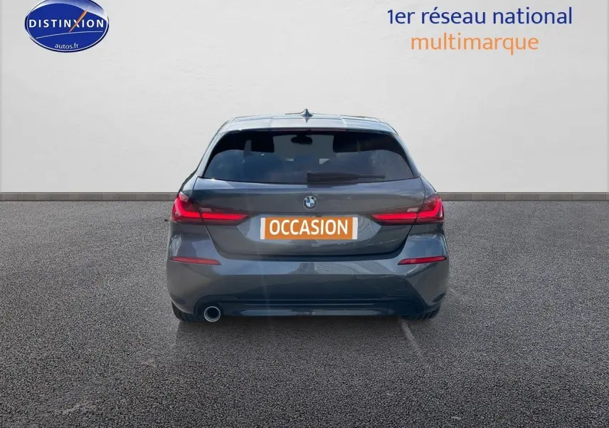 Vue arrière d'une BMW Série 1 gris minéral métallisé avec feux LED et plaque d'immatriculation "OCCASION" visible.