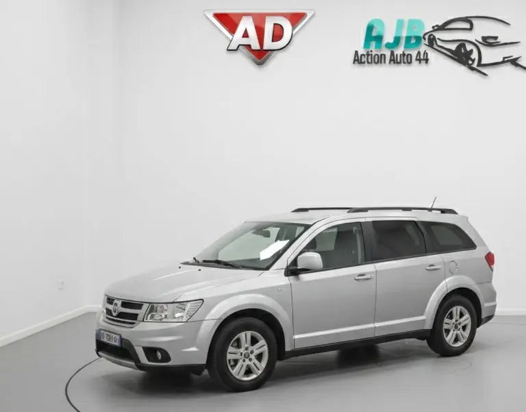 Vue arrière du coffre ouvert d'un FIAT Freemont gris, montrant la troisième rangée de sièges en position verticale.