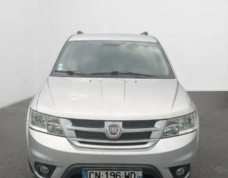 Coffre ouvert vu de l'arrière d'un FIAT Freemont gris, montrant l'espace de chargement et la banquette arrière noire.