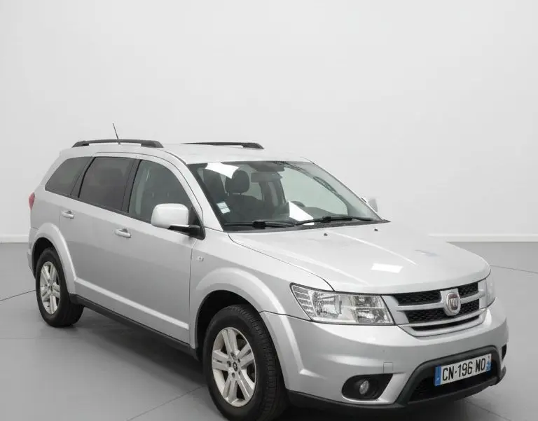 Vue intérieure côté droit sur la deuxième rangée de sièges noirs en tissu du Fiat Freemont gris 7 places.