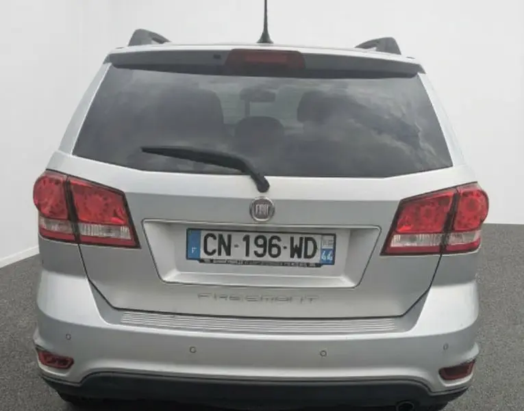 Écran multifonction intérieur montrant l'aide au stationnement du Fiat Freemont gris, vue rapprochée du tableau de bord.