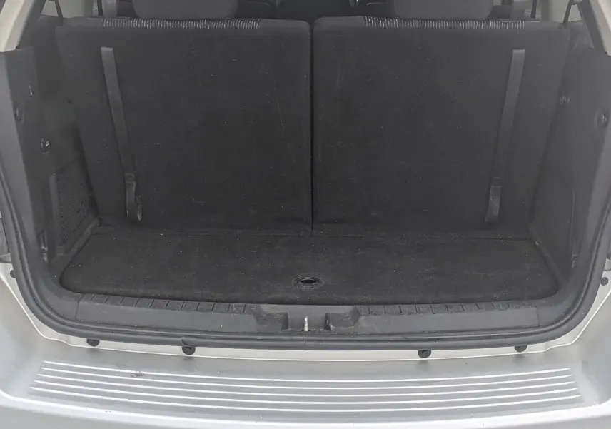 Vue avant d'un FIAT Freemont gris 2012 avec calandre chromée et phares halogènes, sur fond neutre intérieur.