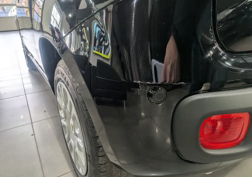 Gros plan sur l'aile arrière droite noire Cinéma de la FIAT Panda 1.0 70 CH Hybrid City avec feu arrière rouge visible.