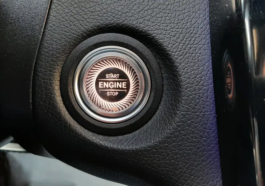 Bouton start/stop moteur en gros plan sur tableau de bord noir du Mercedes GLC Coupé 300 4MATIC AMG Line 2019.