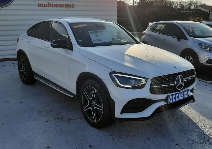 Mercedes GLC Coupé blanc vu en 3/4 avant droit, avec jantes AMG noires et calandre étoilée distinctive.