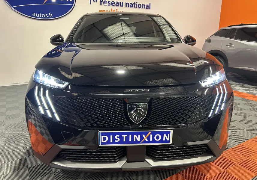 Vue avant du Peugeot 3008 III Hybrid noir avec phares LED allumés et calandre au lion distinctif.
