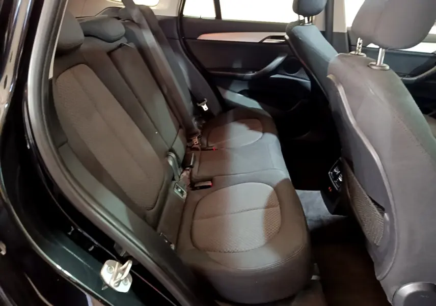 Vue intérieure côté gauche des sièges arrière noirs en tissu du BMW X1 sDrive20i Business Design 2020.