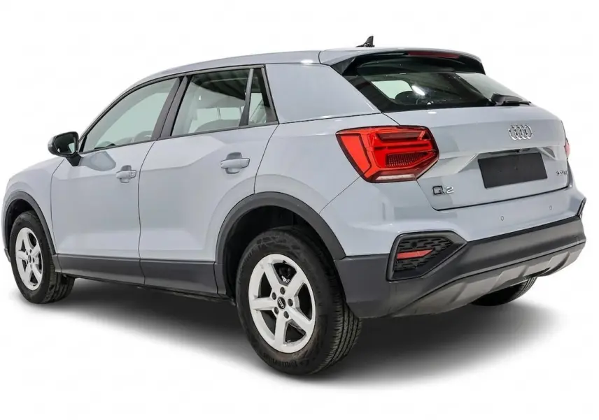 Audi Q2 gris vue 3/4 arrière droit, hayon fermé et feux arrière rouges bien visibles.