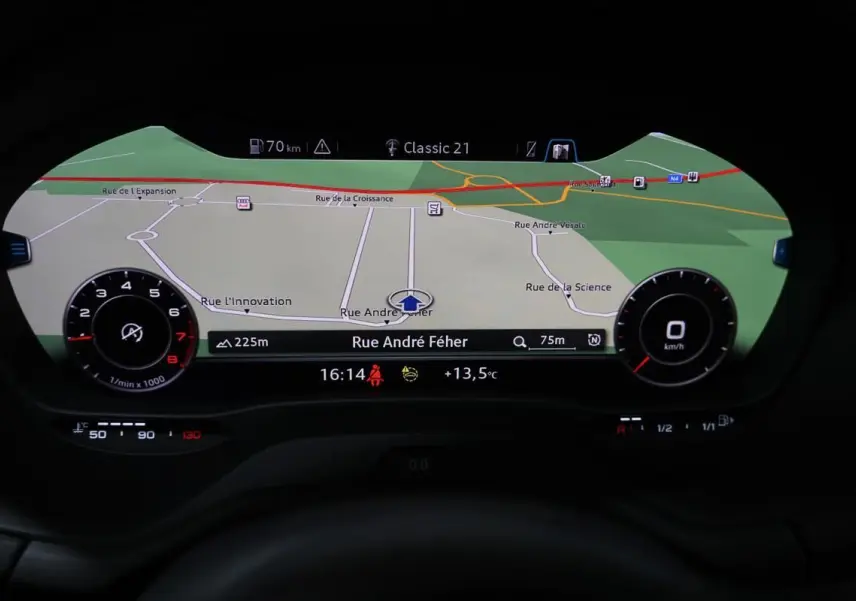 Affichage du virtual cockpit Audi Q2 TFSI 110 gris, montrant la navigation GPS avec carte et informations de conduite.