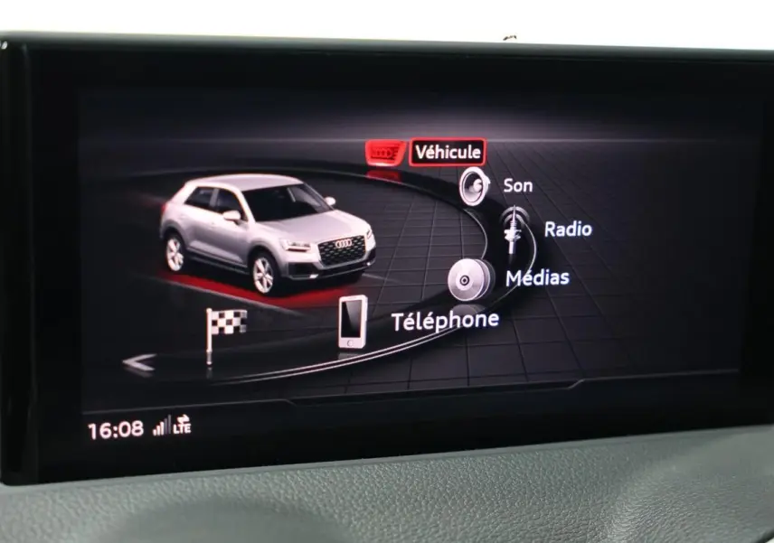 Écran central affichant l'interface multimédia avec une Audi Q2 grise vue de trois quarts avant virtuelle.