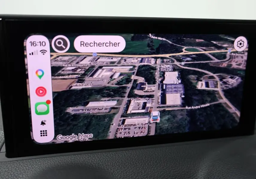 Écran GPS en mode vue satellite dans l’Audi Q2 TFSI 110 gris, affichant une carte détaillée avec navigation active.