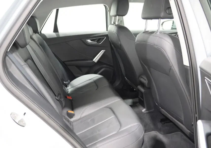Vue intérieure côté gauche montrant les sièges arrière en cuir noir de l'Audi Q2 TFSI 110 gris de 2023.