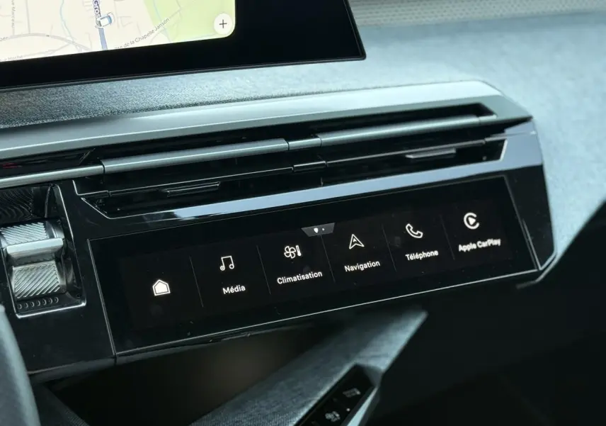 Vue rapprochée de la console centrale du Peugeot 5008 Hybrid 2026, écran tactile avec menu multimédia et finition Alcantara gris.