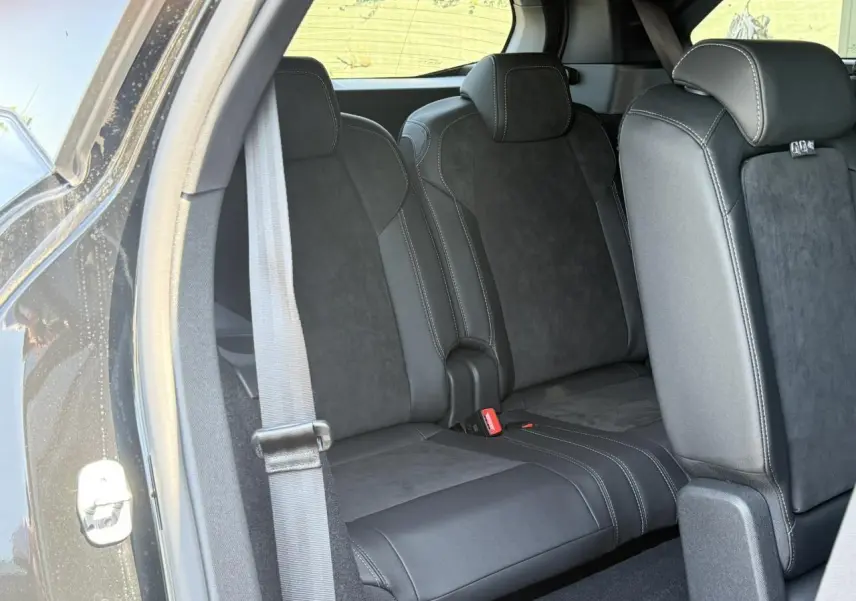 Vue intérieure côté gauche sur la banquette arrière en Alcantara noir du Peugeot 5008 Hybrid 2026 avec ceinture grise visible.
