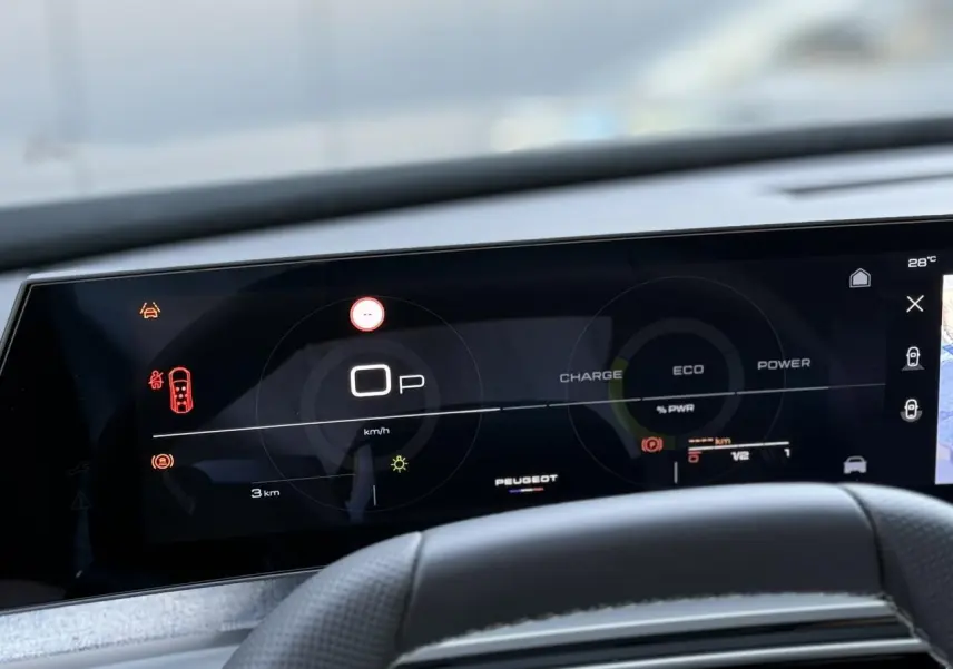 Tableau de bord numérique du Peugeot 5008 Hybrid 2026 vu de face, affichage mode ECO et vitesse à zéro.