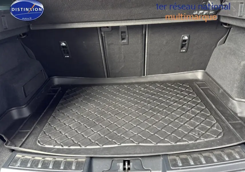 Coffre spacieux du Range Rover Evoque 2019 avec tapis de protection noir et banquette arrière rabattable.