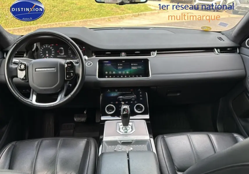Intérieur noir du Range Rover Evoque 2019, vue frontale sur tableau de bord, volant cuir et console centrale tactile.